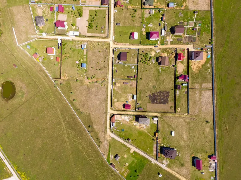 Top-down aerial view of rural land parcels with scattered homes, fence lines and dirt roads
